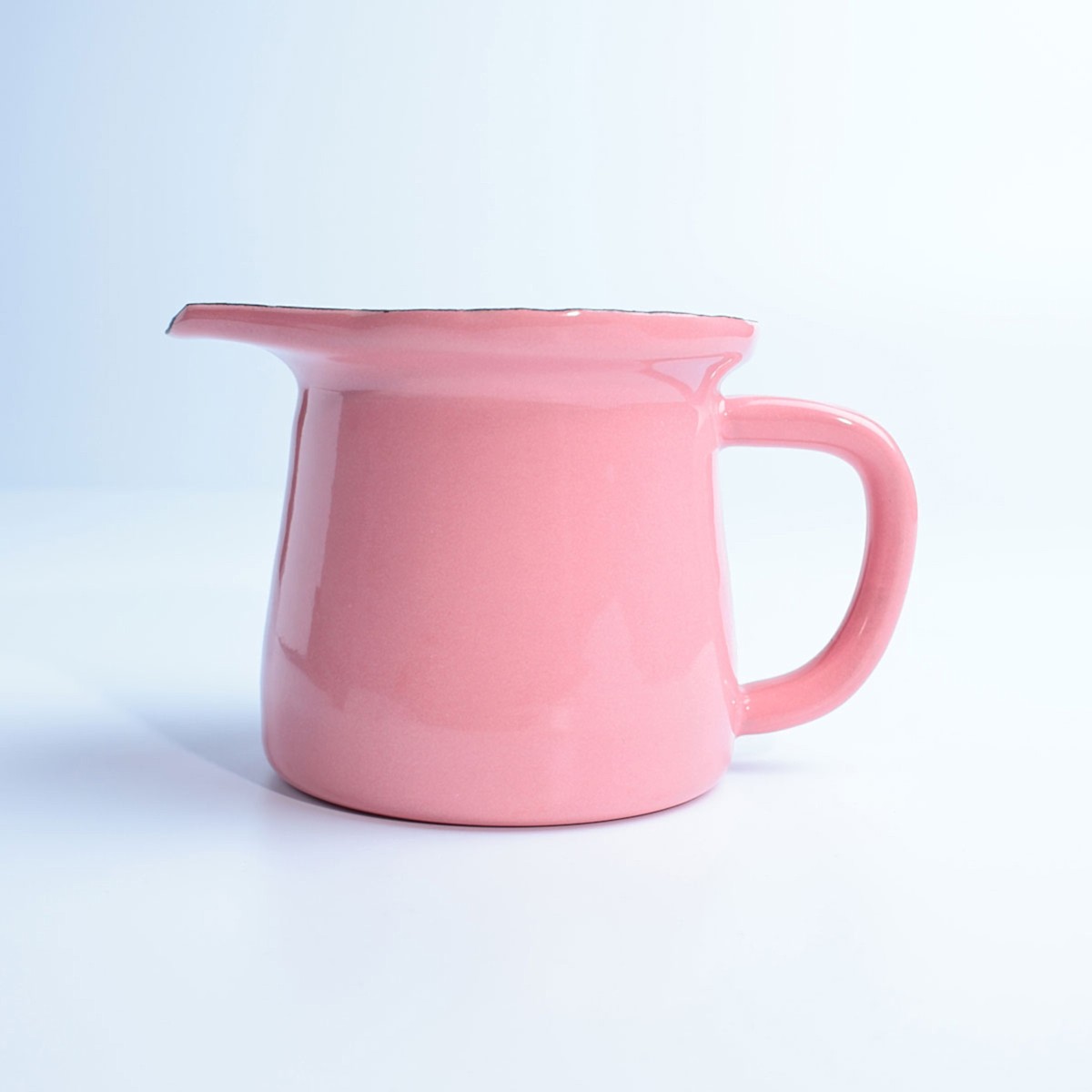 Beyaz zemin üzerinde, kulplu ve ağızlı, parlak pembe renkte emaye sosluk.